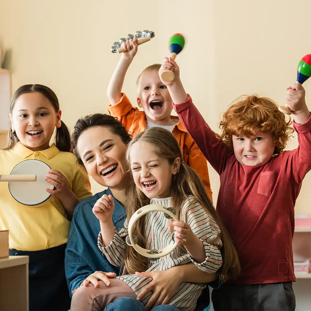 Aufgeregte Kinder verschiedener Ethnien spielen Musikinstrumente in der Nähe eines glücklichen Lehrers.
